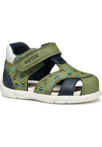 Zielone i granatowe sandały dziecięce z zapięciem na rzep, ozdobione wzorami w niebieskie, żółte i czarne motywy morskie, z otwartą konstrukcją i gumową podeszwą.