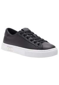Black leather sneaker with round toe, flat white rubber sole, and black laces. Features a logo detail on the side and smooth texture.