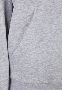 Grijze sweatshirt met een zachte textuur, voorzien van een voorvak en geribbelde boorden. De stof heeft een subtiel gemêleerd patroon.