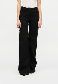 Μαύροι παντελόνες με φαρδιά μπατζάκια από ανθεκτικό τζιν ύφασμα, με κούμπωμα με κουμπιά στο εμπρός μέρος και πλαϊνές τσέπες, με ομαλή υφή και χωρίς ορατά σχέδια.