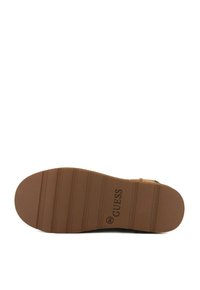 Sole in gomma marrone con scanalature orizzontali; contrassegnata con il logo "GUESS". Forme complessive circolari e rettangolari con una superficie testurizzata.