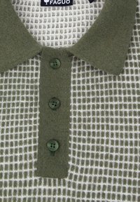 Groene poloshirt met een getextureerd breipatroon, met een kraaghalslijn, drie donkergroene knopen en een wit ruitpatroon. Merklabel zichtbaar.