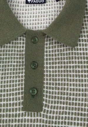 Polo vert avec un motif en maille texturé, doté d'un col, de trois boutons vert foncé et d'un design à carreaux blanc. Étiquette de marque visible.