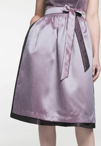 Jupe en satin lilas avec une texture lisse, un nœud à la taille, des poches et un ourlet noir contrastant présentant un motif à pois subtil.