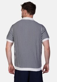 Marineblau-weißer gestreifter Polo mit kurzen Ärmeln, ausgestattet mit einem Kragen und gerippten Bündchen. Der Stoff ist glatt und hat eine taillierte Passform.