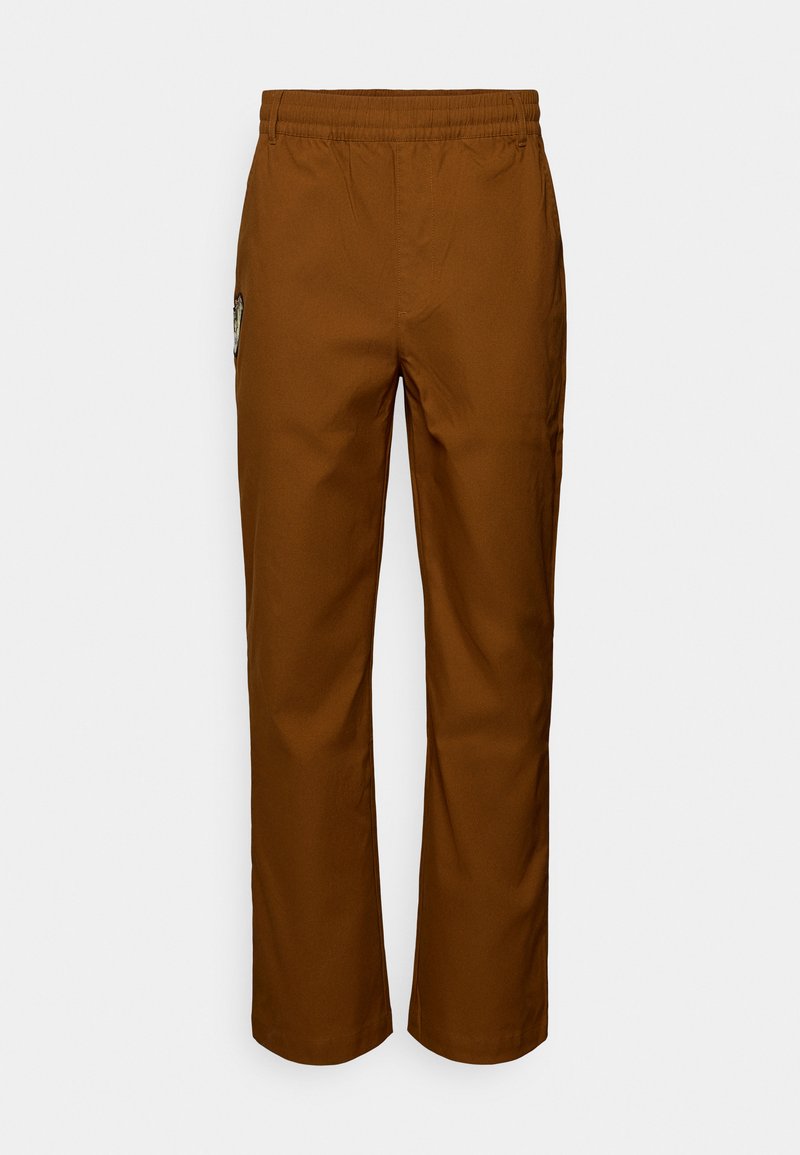 Καφέ, ελαφριά παντελόνια με ελαστική μέση, ίσια γραμμή στα πόδια, πλαϊνές τσέπες και διακοσμητικό έμπλαστρο στην αριστερή πλευρά.