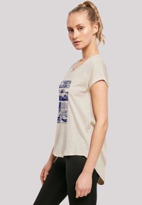 Beige cotton t-shirt with a relaxed fit, round neck, and short sleeves. Features blue printed text and images related to the Austin Allegro.