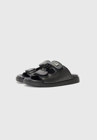 Sorte sandaler med en teksturert overflate, åpen tådesign og doble borrelåsremmer for justerbar passform. Gummisåle for grep og holdbarhet.