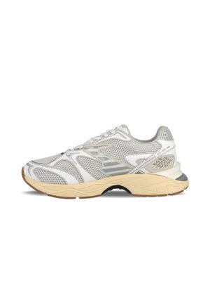 Scarpa da ginnastica a rete grigia chiara con accenti bianchi, suola texturizzata, punta rotonda e dettagli riflettenti. Suola in gomma flessibile con grip.