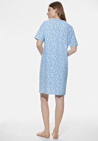 Nuisette bleu clair fabriquée en tissu doux, ornée d'un motif floral, avec des manches courtes et une coupe mi-genoux. Design simple et décontracté.