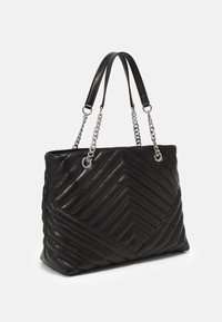 Czarna pikowana torebka ze skóry, z wzorem w jodełkę, srebrnymi łańcuszkowymi detalami oraz podwójnymi skórzanymi uchwytami. Gładka faktura.