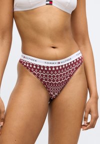 Tommy Hilfiger sarkanas un baltas rakstainas siksnītes apakšveļa ar mīkstu adījuma tekstūru un baltu elastīgu jostu, kurā iekļauts logotipa elements.