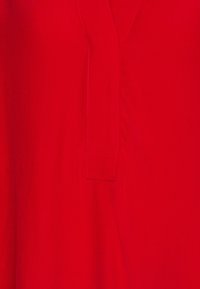 Rotes Kleid mit V-Ausschnitt, seitlichen Nähten und einem glatten, leichten Stoff mit subtiler glänzender Optik. Einfaches Design, keine Muster oder Verzierungen.
