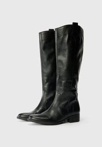Schwarze Lederstiefel bis zum Knie mit glatter Textur, traditioneller Naht und niedrigem Blockabsatz, die ein dezentes geschwungenes Design aufweisen.