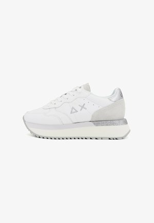 Sneaker bianco con tallone in camoscio, dettagli in argento e suola in gomma testurizzata. Presenta un design con lacci e un logo sottile sul lato.