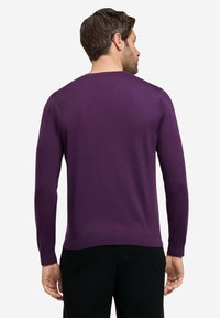Maglione viola a maniche lunghe con scollo rotondo, polsini a costine e una texture liscia, caratterizzato da un design aderente in vita.