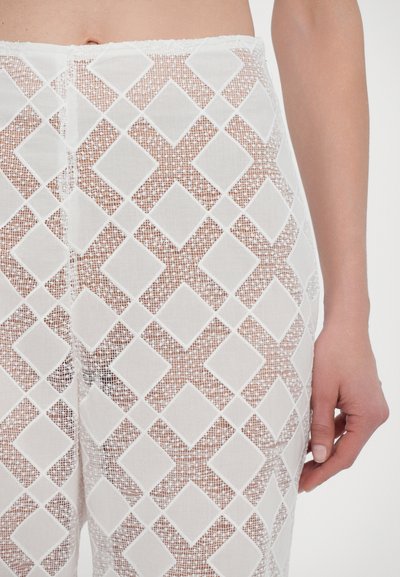 Witte, gestreepte broek met een ruitpatroon. De stof is semi-transparant met een gladde textuur, waardoor de huid eronder wordt benadrukt.