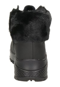 Botte noire imperméable avec un bord en fausse fourrure, semelle en caoutchouc texturé et talon renforcé. Design élégant avec un matériau supérieur lisse.