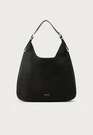 Bolso de hombro de ante negro con parte superior redondeada, herrajes plateados y textura suave. Cuenta con un logo en la parte inferior.