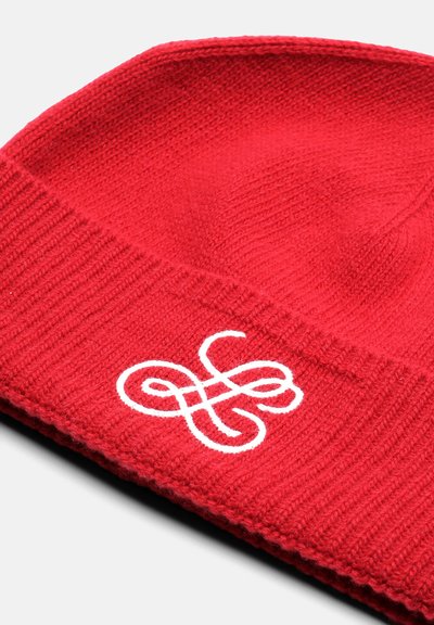 Rdeča pletena kapa z rebrastim vzorcem in belim vezenim logotipom spredaj. Okrogla oblika, lahka material.