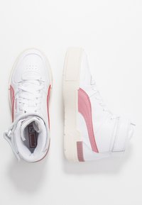 White high-top sneakers with pink accents. Leather and synthetic material, textured rubber sole, and lace-up design with perforated detail.