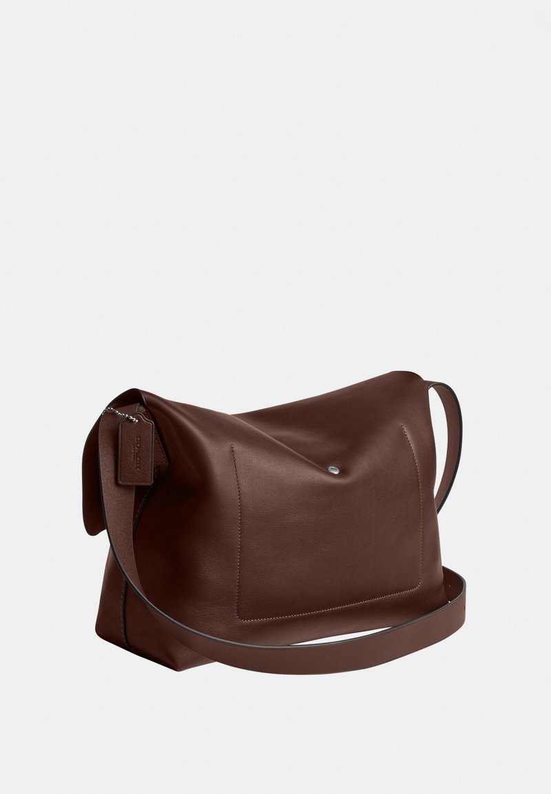 Donkerbruine leren schoudertas met een voorvak, enkele riem en een kleine metalen knoopdetail op een effen achtergrond.