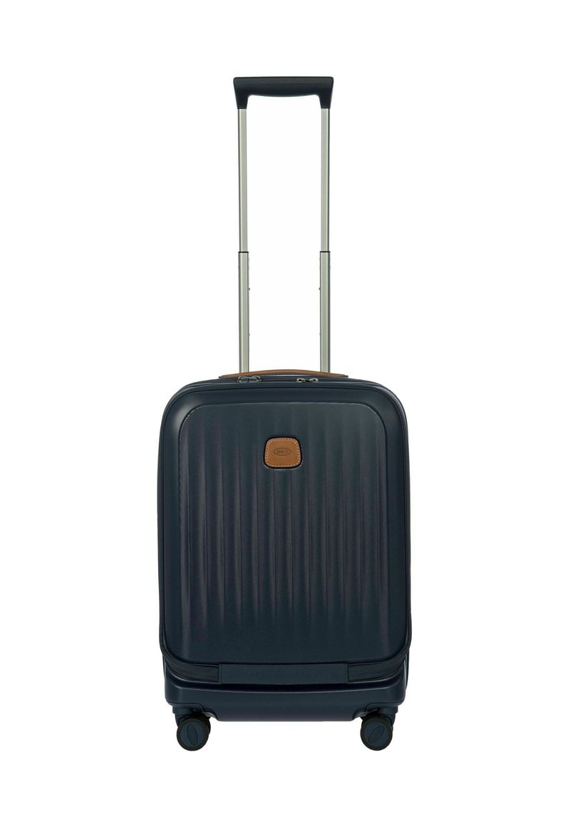 Valigia rigida blu navy con texture a coste, accento in pelle marrone, manico estraibile e quattro ruote girevoli a 360 gradi.