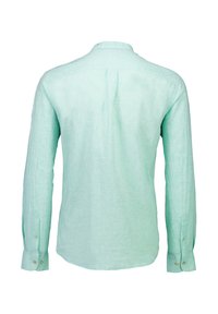 Camicia a maniche lunghe di un verde chiaro, realizzata in un tessuto texture. Presenta un colletto con bottoni e polsini abbottonati con una singola piega sul retro.