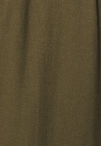 Tissu tissé vert olive avec une surface texturée, affichant une finition mate et une couleur uniforme sur le matériau.
