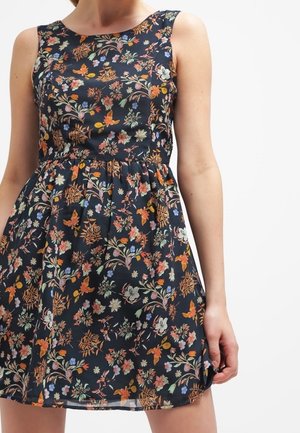 Robe sans manches bleu marine avec un motif floral et papillons aux couleurs vives orange, blanc et vert, ajustée à la taille avec une jupe froncée.