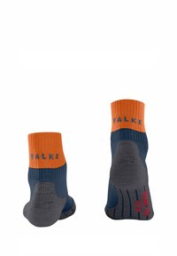 Un paio di calzini alla caviglia con polsini arancioni, parte superiore blu navy e tallone e suola grigi, con il nome del marchio "FALKE" sui polsini.