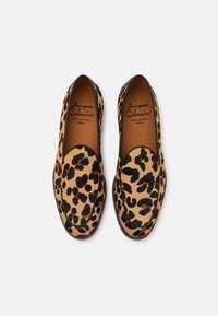 Slangenprint instapschoenen met een zachte vachttextuur, zwarte afwerking en leren binnenzool. Voorzien van een rond neusdesign.