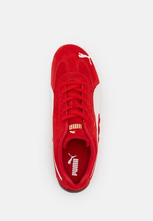 Basket Puma rouge avec détails en suède et mesh, logo Puma blanc sur le côté et la languette, vue de dessus sur fond blanc.