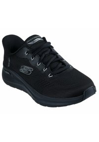Scarpa sportiva nera con tomaia in rete, design con lacci e suola ammortizzata. Logo e dettagli in grigio ben visibili. Materiale leggero e traspirante.