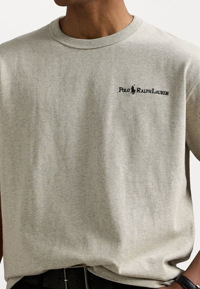 Pelēka kokvilnas T-kreklu ar apaļu kakla izgriezumu un īsām piedurknēm. Uz krūšu ir neliels melns "Polo Ralph Lauren" logo. Gluda tekstūra.