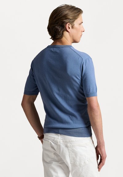 Pull-over à manches courtes et col rond en tricot bleu clair, avec des bords côtelés aux poignets et à l'ourlet, vu de dos.