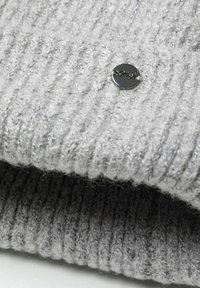 Bonnet en tricot côtelé gris fabriqué en laine douce avec un détail de bouton en métal avec logo. Présente une finition texturée et un ajustement serré.