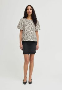 Blumenmuster Kurzarmbluse mit Rundhalsausschnitt, kombiniert mit einem schwarzen Jeansrock. Das Outfit hat eine lockere Passform und ein einfaches Design.