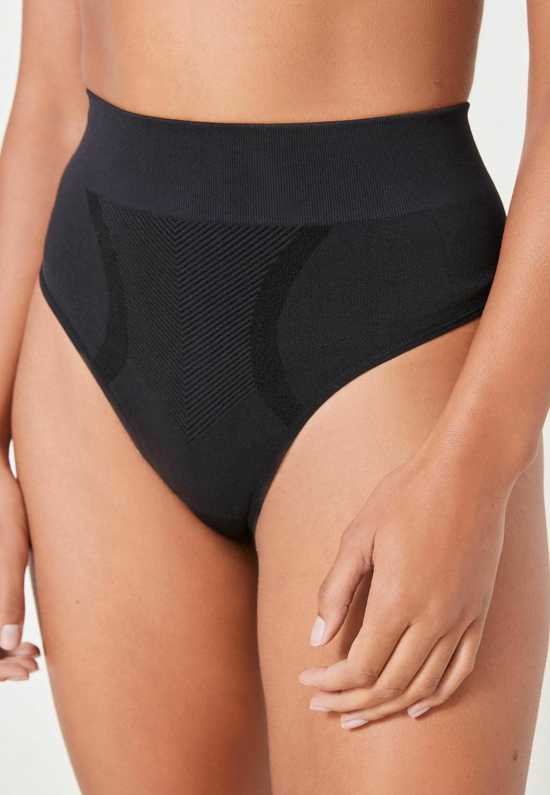 Zwarte hoge taille onderbroek met een naadloos ontwerp, textuurelementen en een gladde afwerking, voorzien van een brede elastische tailleband.