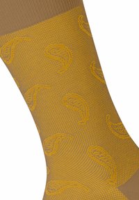 Calze marroni con trama, caratterizzate da un motivo giallo di foglie stilizzate, con un bordo rigato nella parte superiore e una finitura liscia in tutto il calzino.