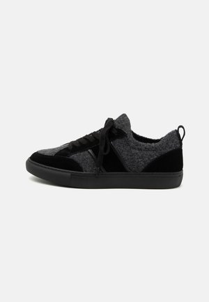 Sneaker élégant en gris et noir, avec une tige texturée, des lacets noirs et une semelle en caoutchouc pour le confort et la durabilité.