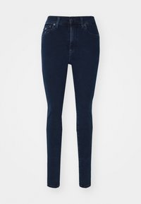 Skinny jeans in dark blue denim, featuring a mid-rise waist, front pockets, and a zip fly with a button closure. Smooth texture, minimal detailing.