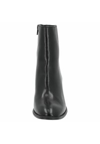 Botín negro de cuero hasta el tobillo con una forma cilíndrica y elegante. Cuenta con un cierre de cremallera en la parte trasera y una superficie lisa y brillante.