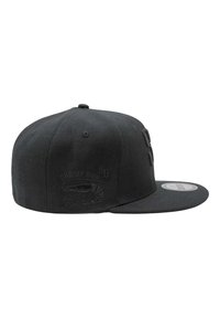 Musta litteälippa snapback-lippis, jossa on kohokuvioitu katkarapulogo ja teksti sivupaneelissa sekä tarra lipan päällä.
