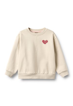 Sweat-shirt crème à manches longues avec poignets et ourlet côtelés, présentant un petit graphique cœur rouge avec le texte « WILD HEART » sur la poitrine.