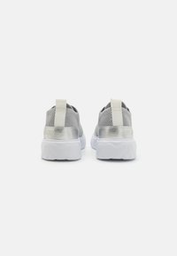 Grey mesh sneakers with silver accents, white rubber sole, and a fabric pull tab on the heel, featuring textured materials and curved design.