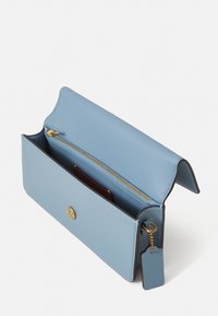 Portafoglio in pelle azzurro chiaro con una tasca con zip, hardware dorato e un'etichetta. Presenta un design elegante e minimalista e una texture liscia.