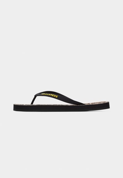 Tongs noires avec semelle texturée et brides noires ornées du logo jaune "DSQUARED2" sur un fond clair uni.