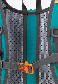 Interno dello zaino teal e grigio con un pannello in rete, spallacci regolabili e una fibbia arancione. Presenta un tessuto testurizzato e un design leggero.