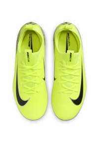 Los tacos de fútbol Nike Mercurial de un brillante color amarillo presentan un diseño aerodinámico con acentos negros, una superficie texturizada y un sistema de cordones tradicional.